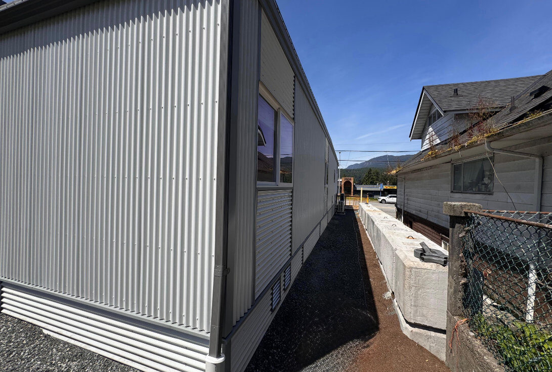 Exterior side view of the white corrugated metal building