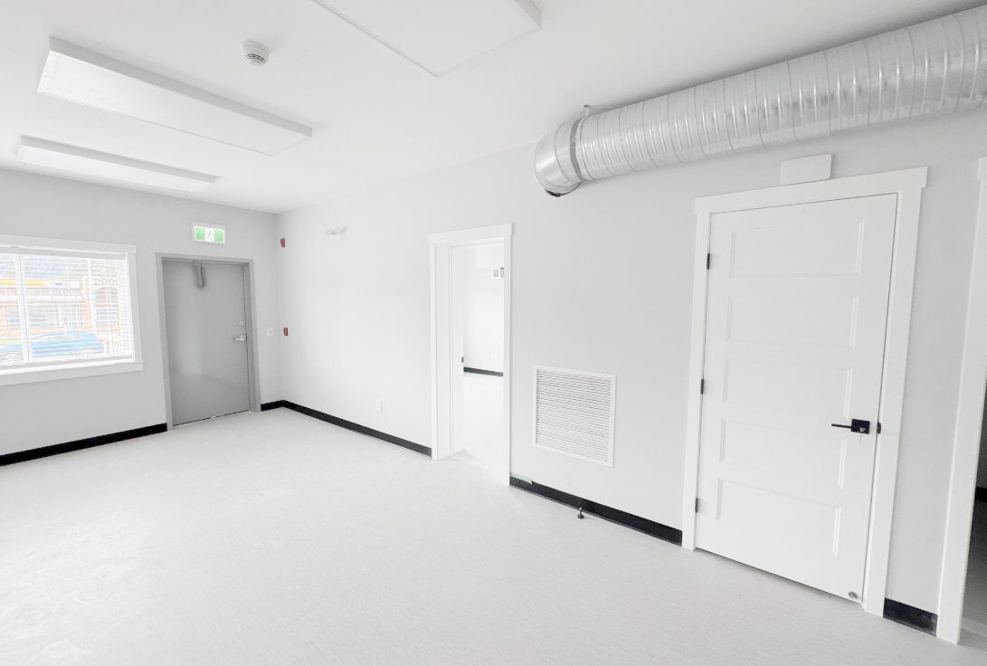 Interior common room with exposed ductwork and doors